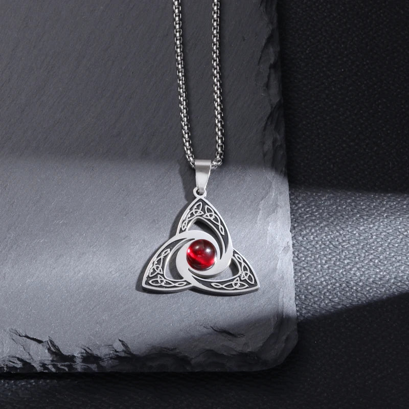 Silver Celtic Trinity Knot pendant with red crystal on dark slate