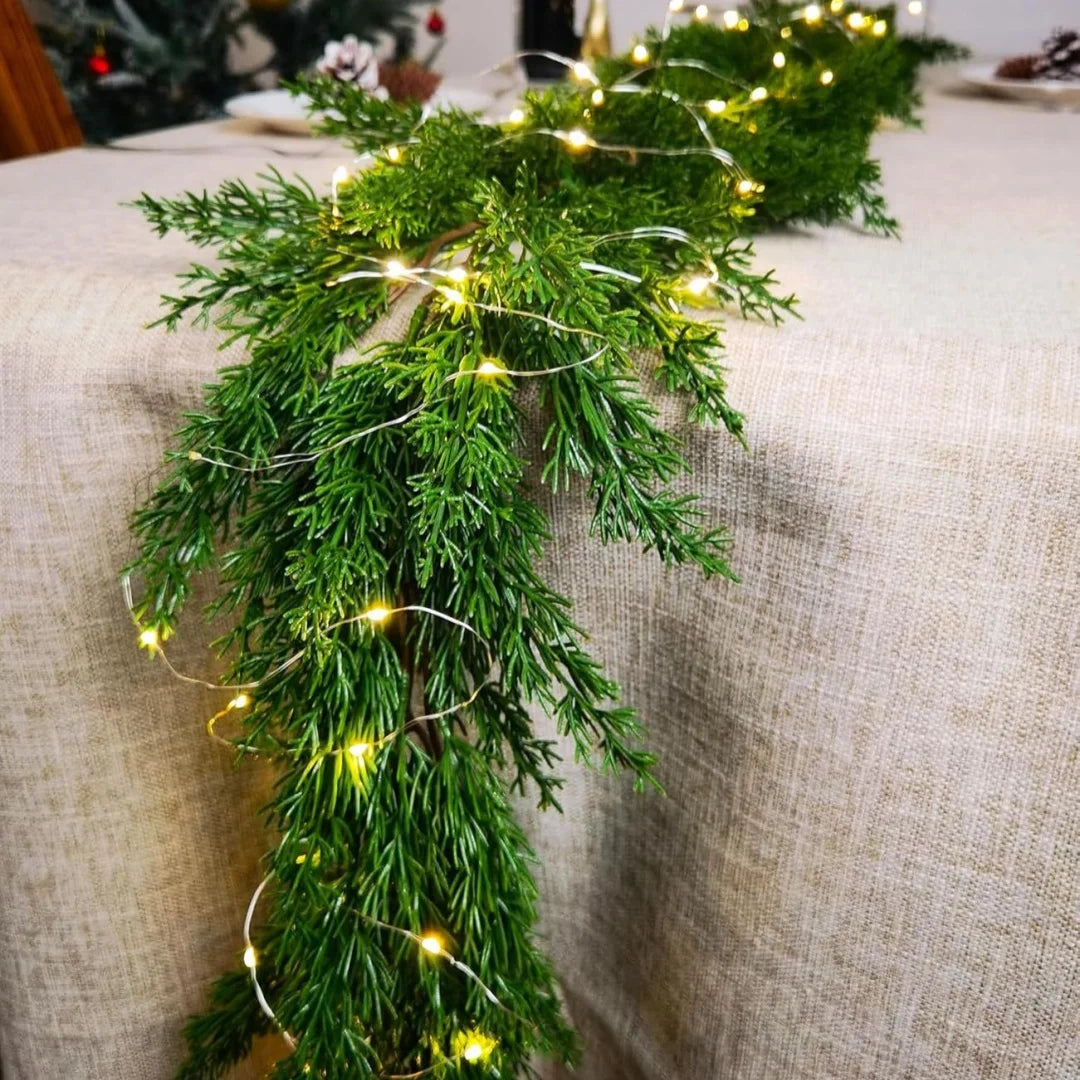 Cedar garland with warm fairy lights draped on a table