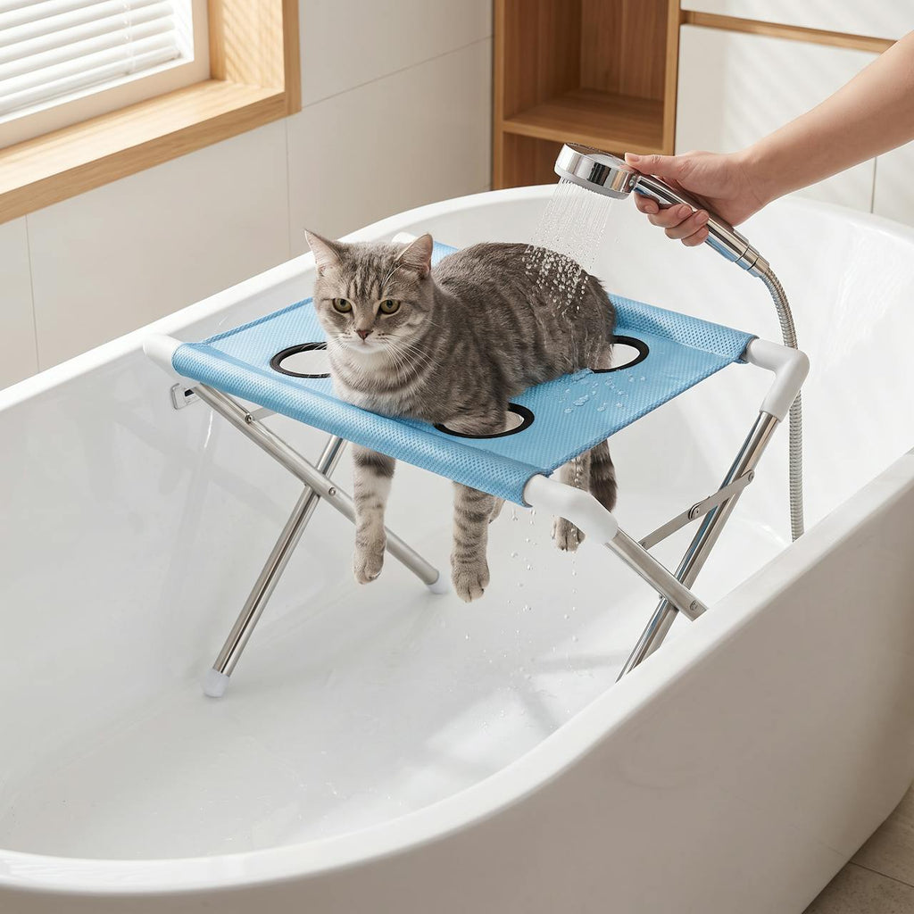 Tabby cat on the pet bath stand in a bathtub being gently rinsed